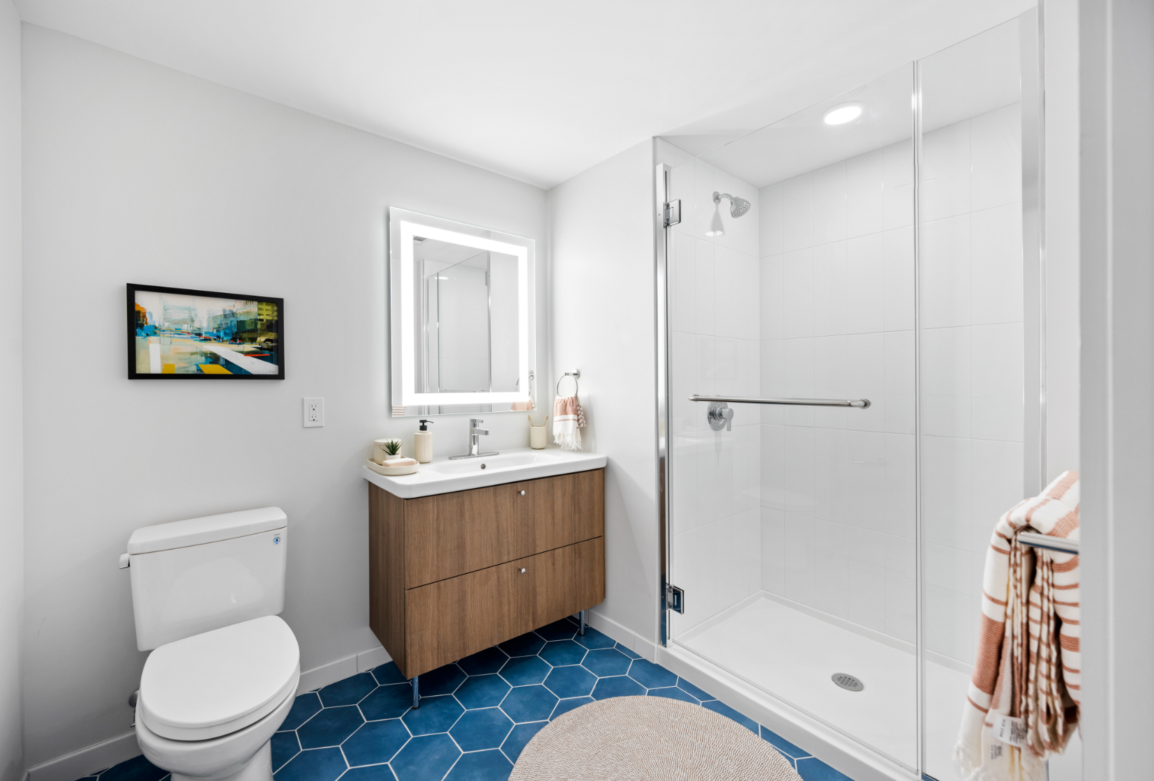 Backlit mirror and tile accents for an elegant bathroom.